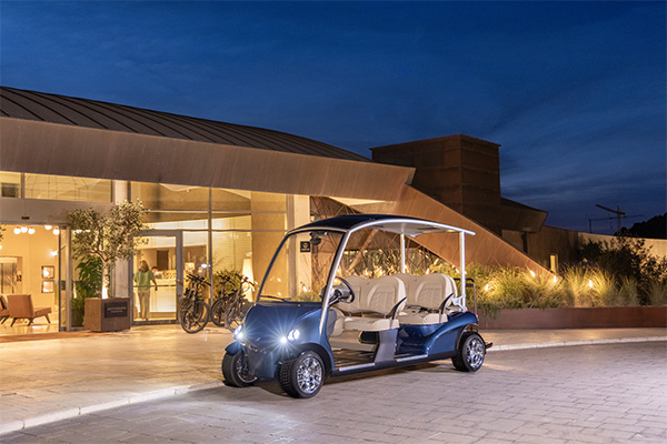 A blue golf cart in front of a venue